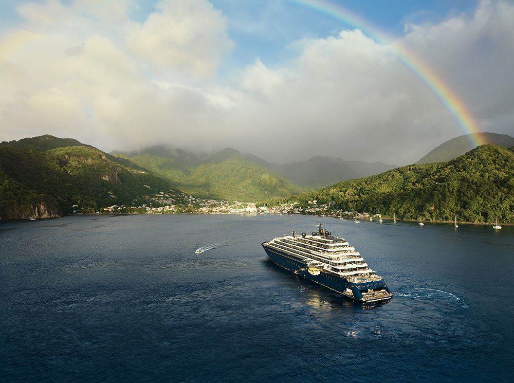 ritz carlton yacht in water with rainbow